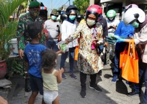 Pakai Helm, Wali Kota Surabaya Tri Rismaharini Keliling Bagi Masker
