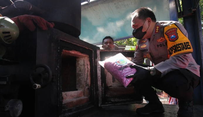 Kapolrestabes Surabaya Kombes Pol Pasma Royce (kanan) memasukkan sabu ke alat incinerator saat kegiatan pemusnahan barang bukti narkoba di Polrestabes Surabaya, Jumat (17/5/2024). ANTARA/Didik Suhartono