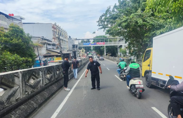 Petugas menunjukan lokasi kecelakaan antara sepeda motor ojek daring dengan truk boks di Jalan Bandengan Utara tepatnya di turunan flyover Bandengan, Tambora, Jakarta Barat pada Jumat (24/5/2024) sekira pukul 12.30 WIB. ANTARA/HO-Polres Jakbar