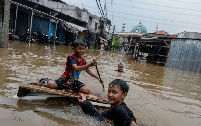Anak-anak bermain air saat terjadi banjir di Petir, Kota Tangerang, Banten, Selasa (4/3/2025). Badan Penanggulangan Bencana Daerah (BPBD) Kota Tangerang mencatat terdapat 13 titik genangan air dan banjir di wilayah Kota Tangerang akibat luapan Kali Angke yang dipicu tingginya intensitas hujan sejak Senin (3/3) malam. ANTARA FOTO/Putra M. Akbar/YU